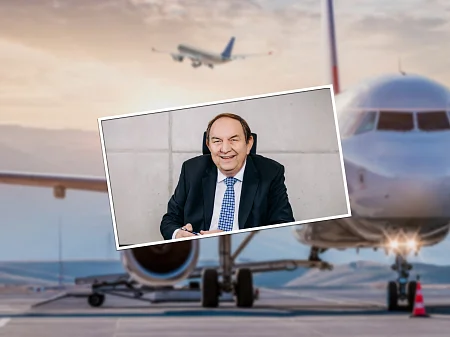 Aeroplane on the tarmac at sunset, with a portrait photo of a smiling businessman in a suit superimposed.