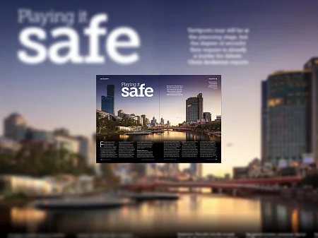 Doppelseitiges Magazinlayout mit Skyline bei Dämmerung, Überschrift „Playing it safe“ und Fluss mit Brücke im Hintergrund.