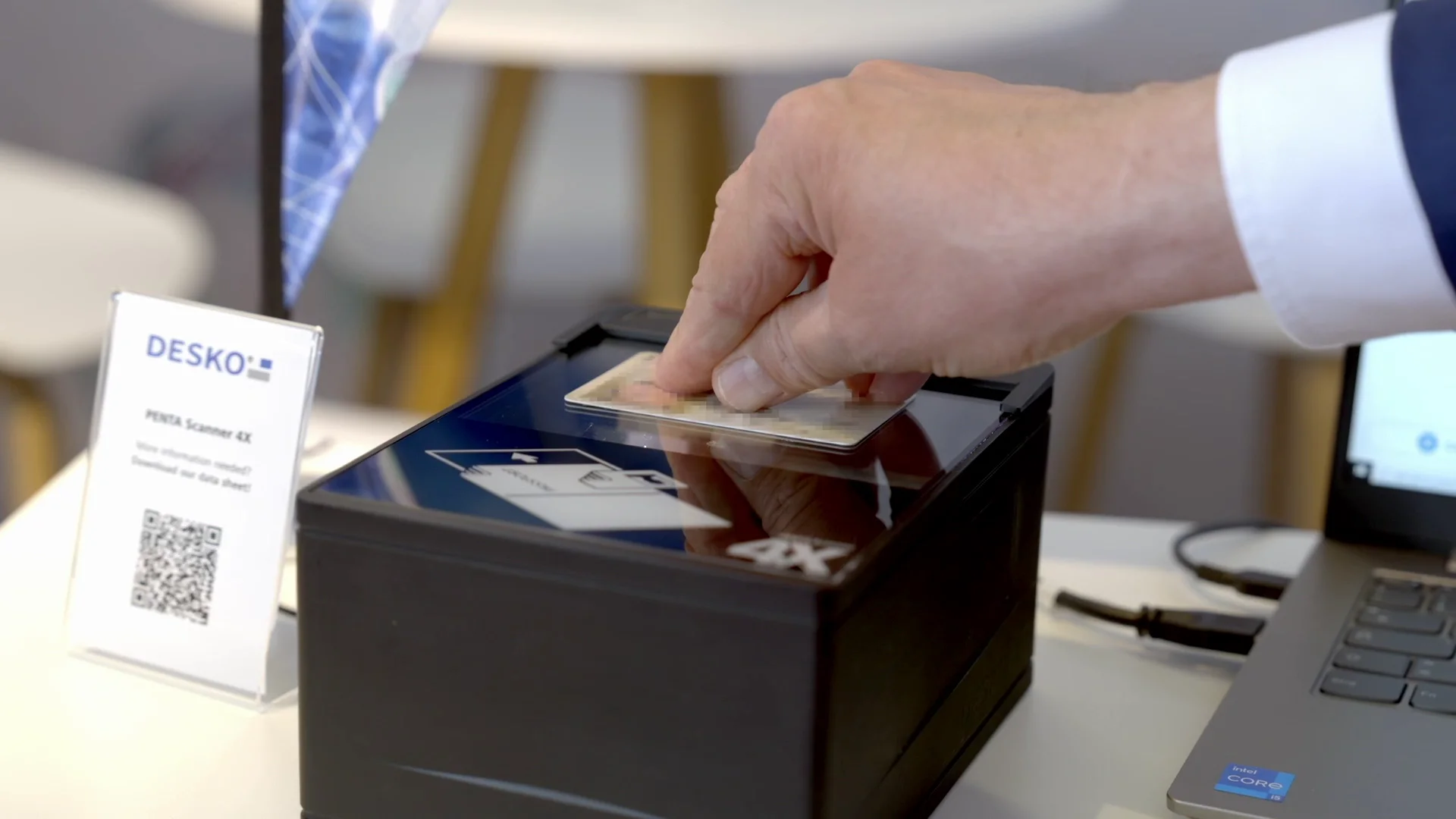 Hand places an ID card on a compact document scanner for digital identity and card verification.