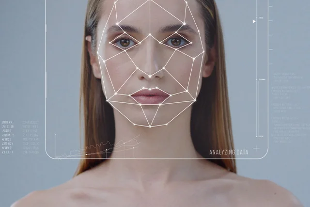 Portr&auml;taufnahme einer Frau, deren Gesicht von geometrischen Linien zur biometrischen Gesichtserkennung &uuml;berlagert ist.