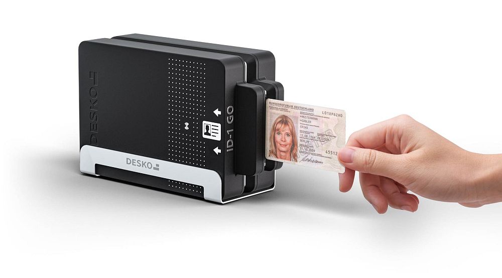 Hand inserts an ID card into a compact DESKO ID-1 GO reader.