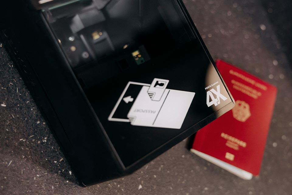 Escáner de pasaportes con un pasaporte tumbado al lado en el desenfoque