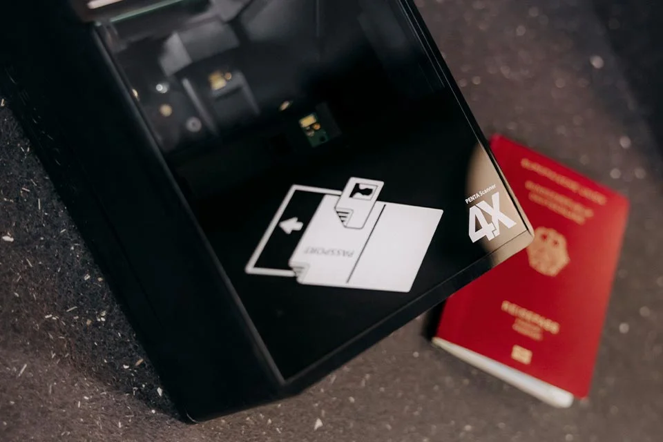 Esc&aacute;ner de pasaportes con un pasaporte tumbado al lado en el desenfoque