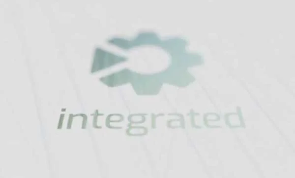 Imagen suavemente difuminada de una rueda dentada estilizada con un tick integrado y la palabra "integrated" sobre fondo claro.
