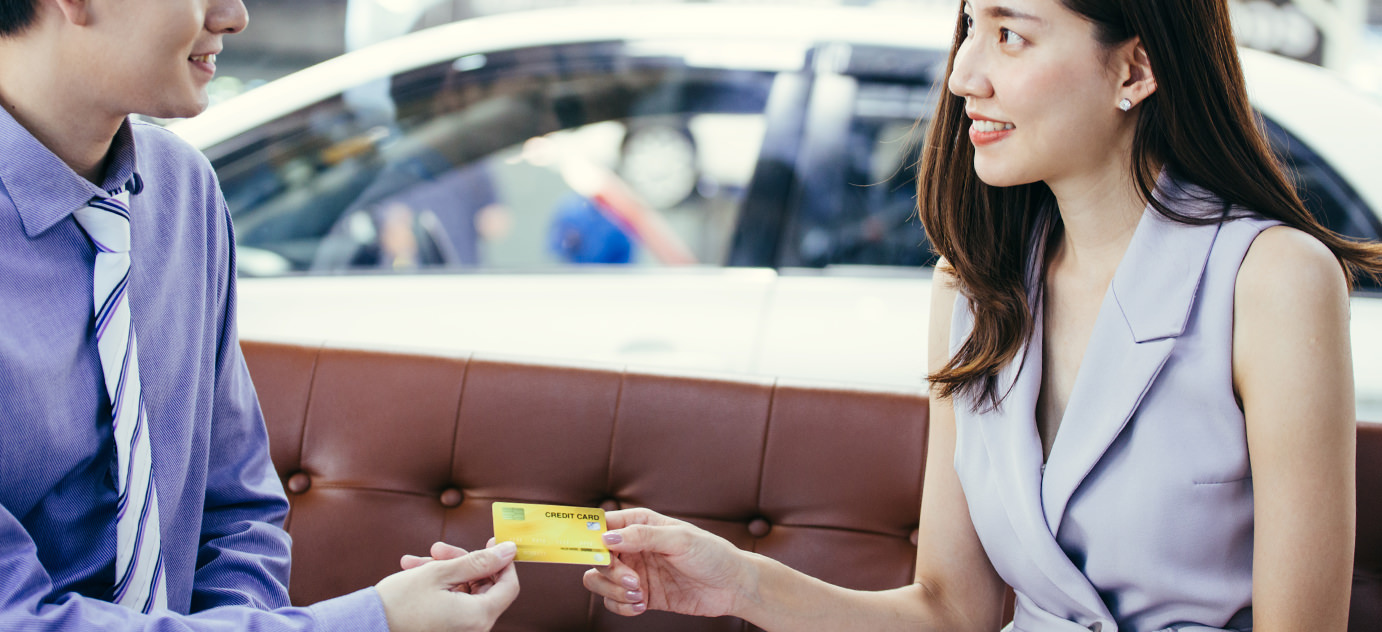Detail of a car with two men shaking hands in the background.