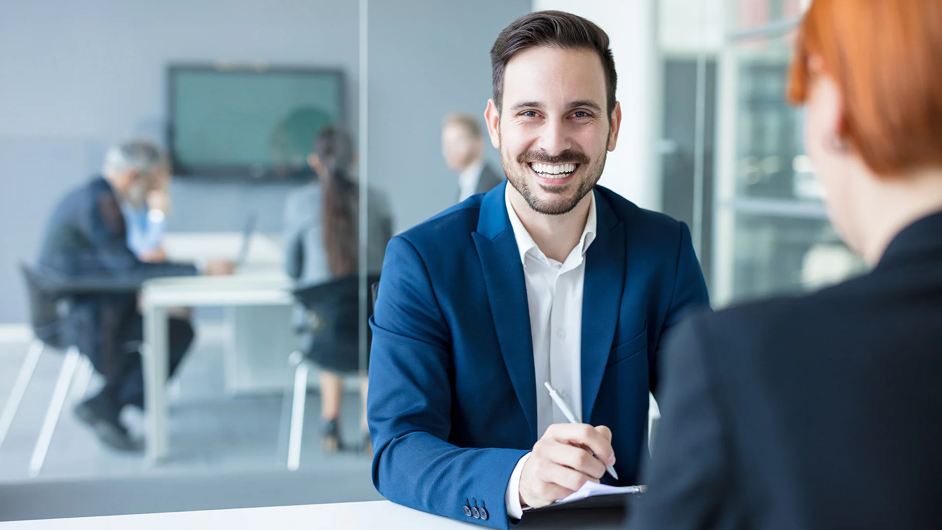 Un client de la banque signe un formulaire.