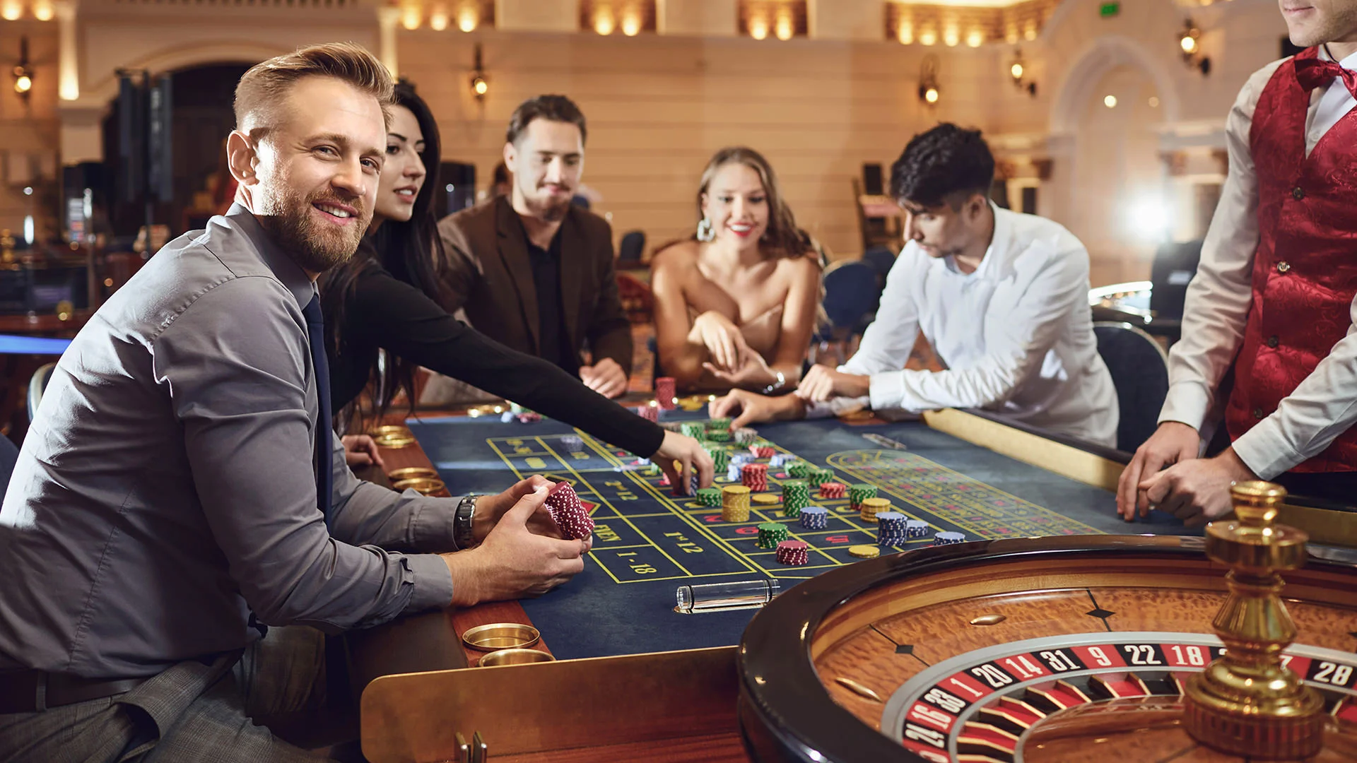 Un groupe de jeunes gens est assis en riant autour d'une table de roulette.