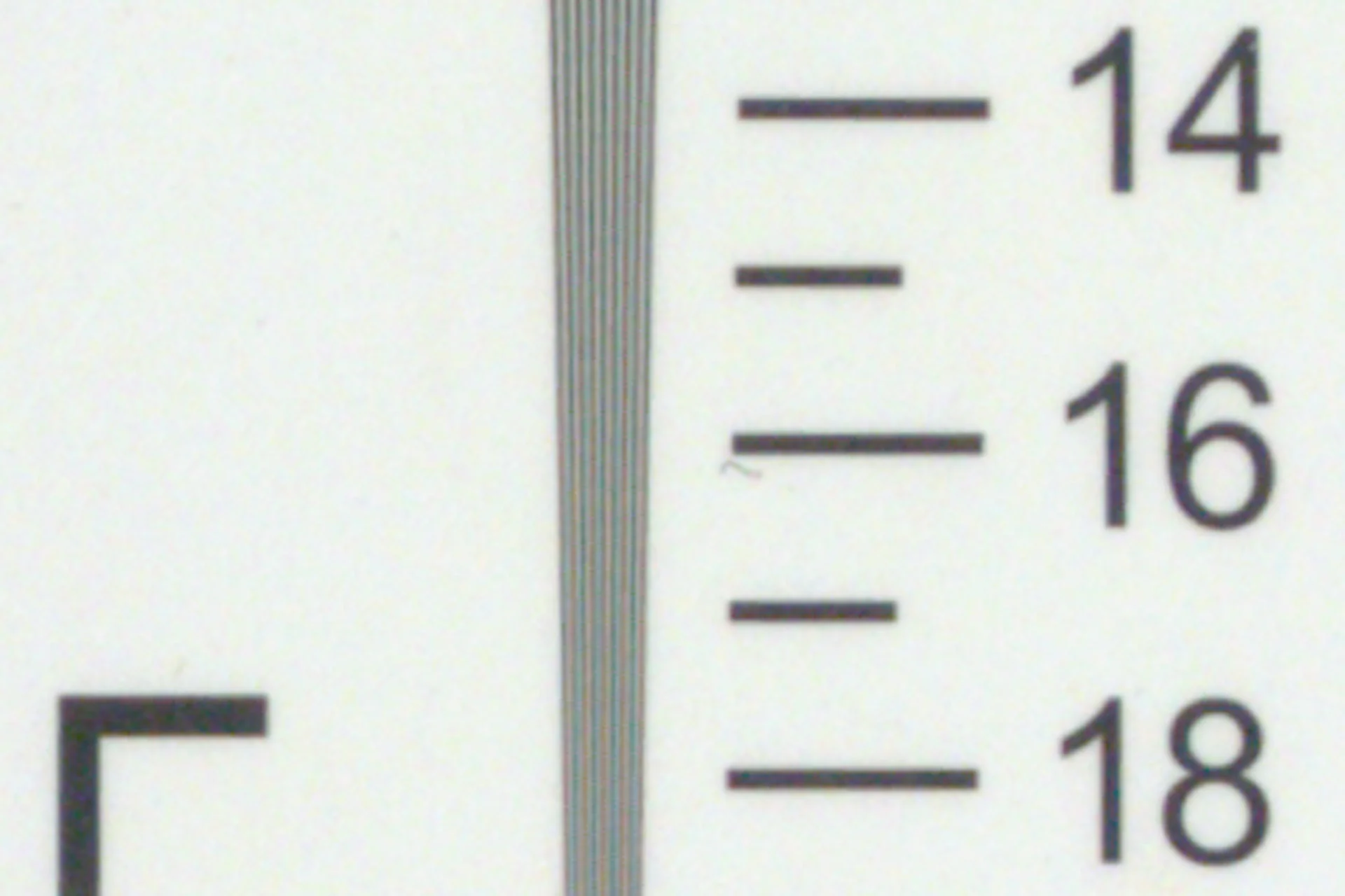 Macro image of a printed scale with fine lines, digits 14-18 and a vertical safety line pattern.