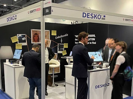 Stand d'exposition de DESKO à l'Identity Week avec des visiteurs assistant à des démonstrations en direct de la vérification de documents.