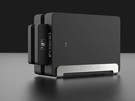 Black DESKO device in a modern design on a dark background, compact shape with metal base and NFC symbol.