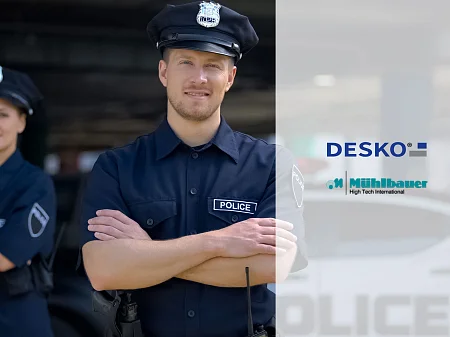 Zwei uniformierte Polizisten mit verschränkten Armen, im Vordergrund ein Beamter, daneben DESKO- und Mühlbauer-Logos.