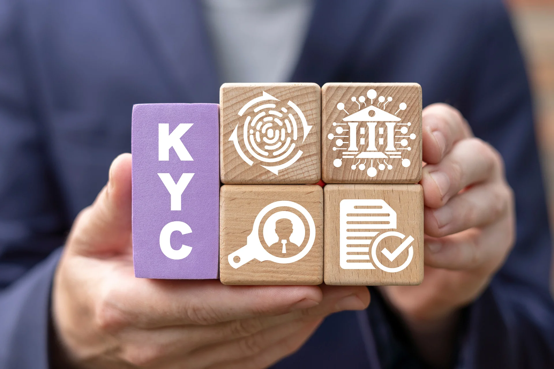 Les mains tiennent des blocs de bois portant l'inscription KYC et des symboles de v&eacute;rification d'identit&eacute;, de banque, de documents et d'examen.